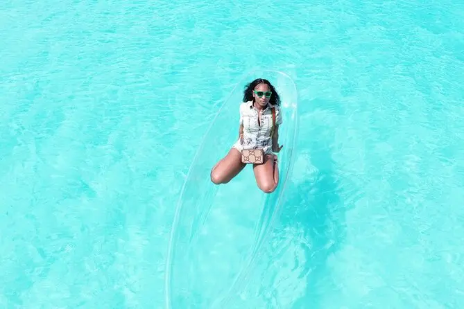Aerial portrait of a guest sitting in a clear kayak in Grand Turk